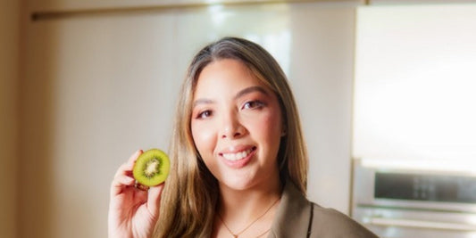 Valentina Díaz sonriendo con un kiwi en su cocina