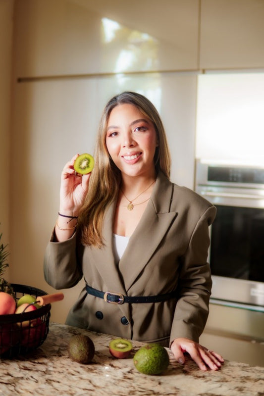 Valentina Díaz sonriendo con un kiwi en su cocina